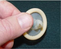 Close-up image of a latex condom being held, representing safe sex practices and prevention methods to reduce the risk of syphilis and other sexually transmitted infections, used for patient education by OC MedDerm